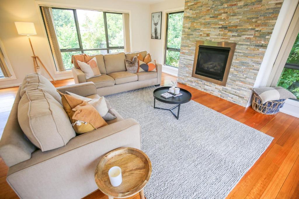 a living room with a couch and a fireplace at Alpine Nest in Bright