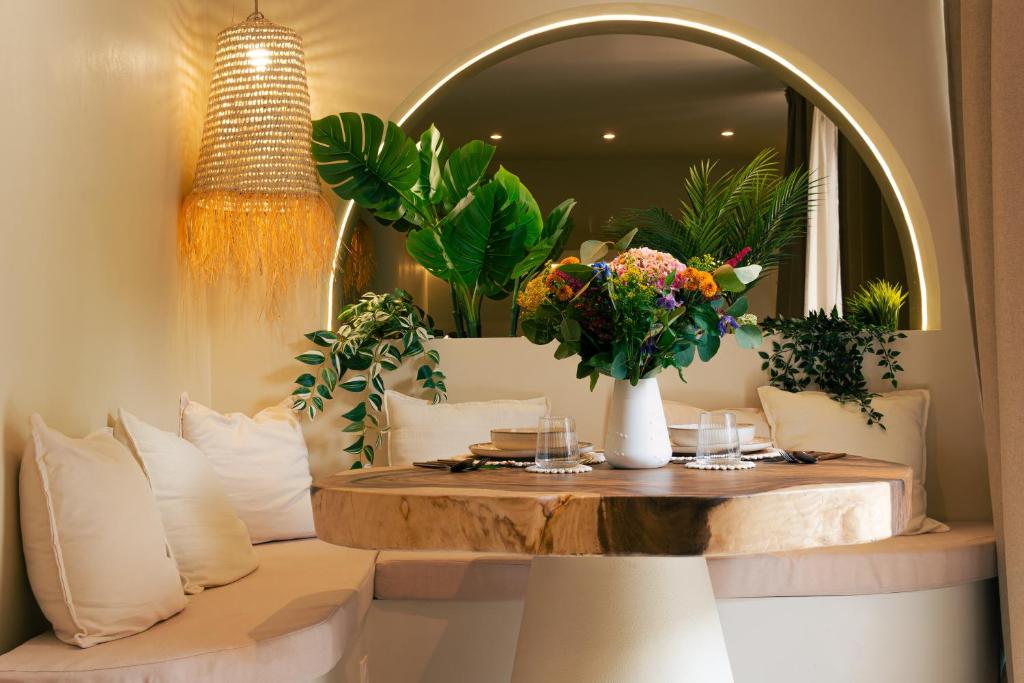 una stanza con un tavolo con fiori e uno specchio di Casa Cinta Évasion Balinaise avec Baignoire Spa a Croix