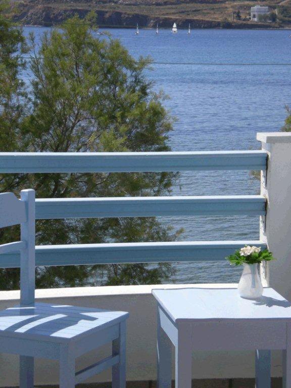 a white bench and a table with a view of the water at Hotel Paros in Parikia