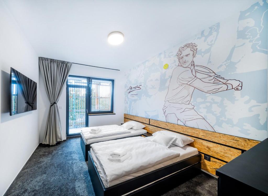 two beds in a room with a mural on the wall at Hotel Break Hradec Králové in Hradec Králové
