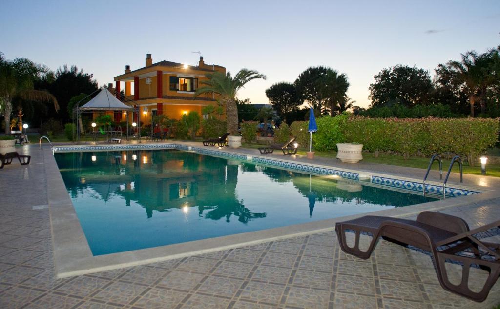ein Schwimmbad mit einem Haus im Hintergrund in der Unterkunft I Due Pini in Sogliano Cavour