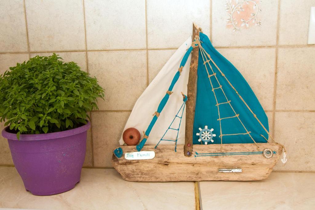 a small wooden boat sitting next to a potted plant at Limnos Family Studios in Angariónes
