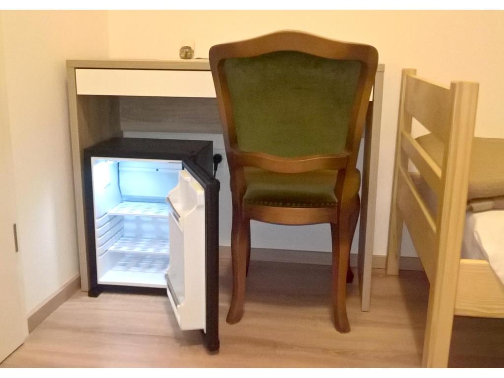 a chair sitting next to an open refrigerator at San Eleuterio Guesthouse in Poreč