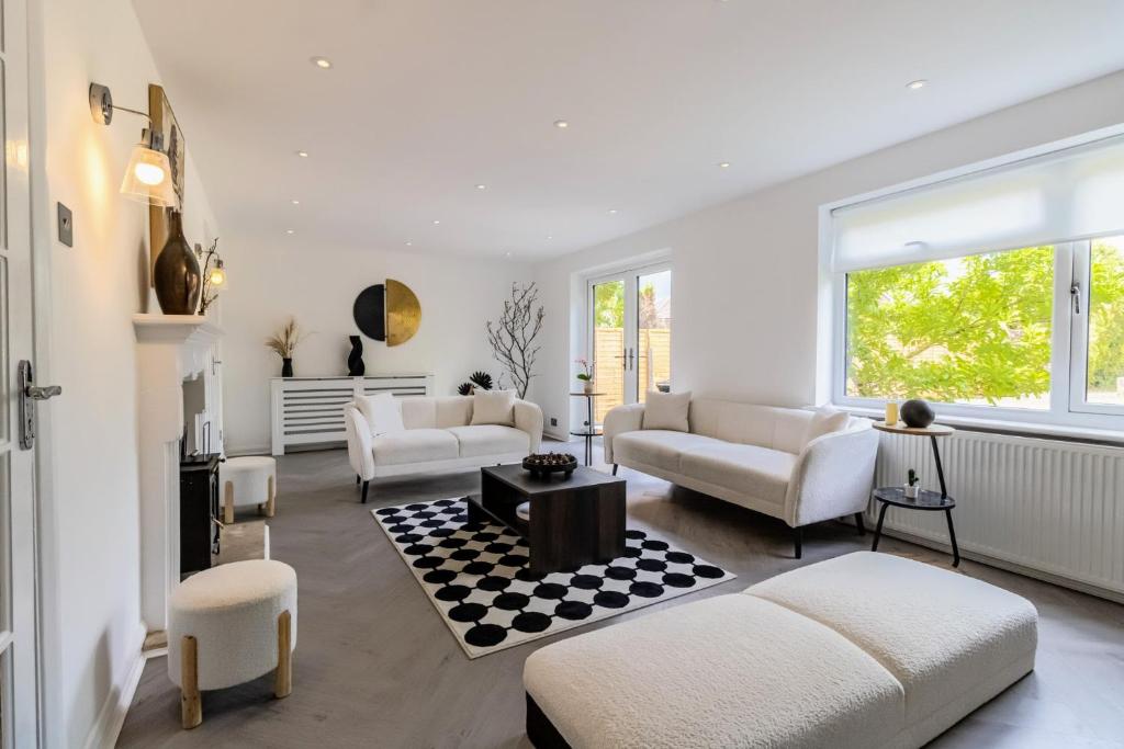 a living room with two couches and a table at Stunning 4-bed Home in Milton Keynes by Renzo, Swimming Pool, Games Room! in Bletchley