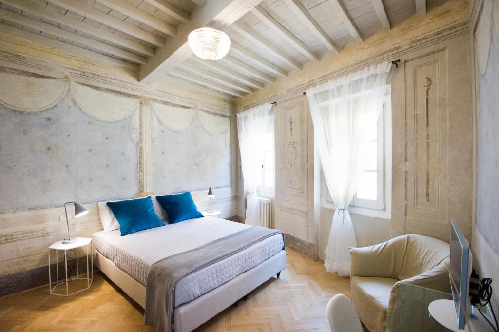 a bedroom with a bed, chair, and a lamp at Il Piccolo Cavour Charming House B&B in Arezzo
