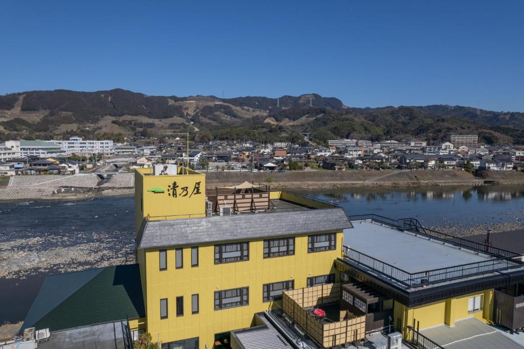 a yellow building next to a body of water at Kiyonoya in Asakura