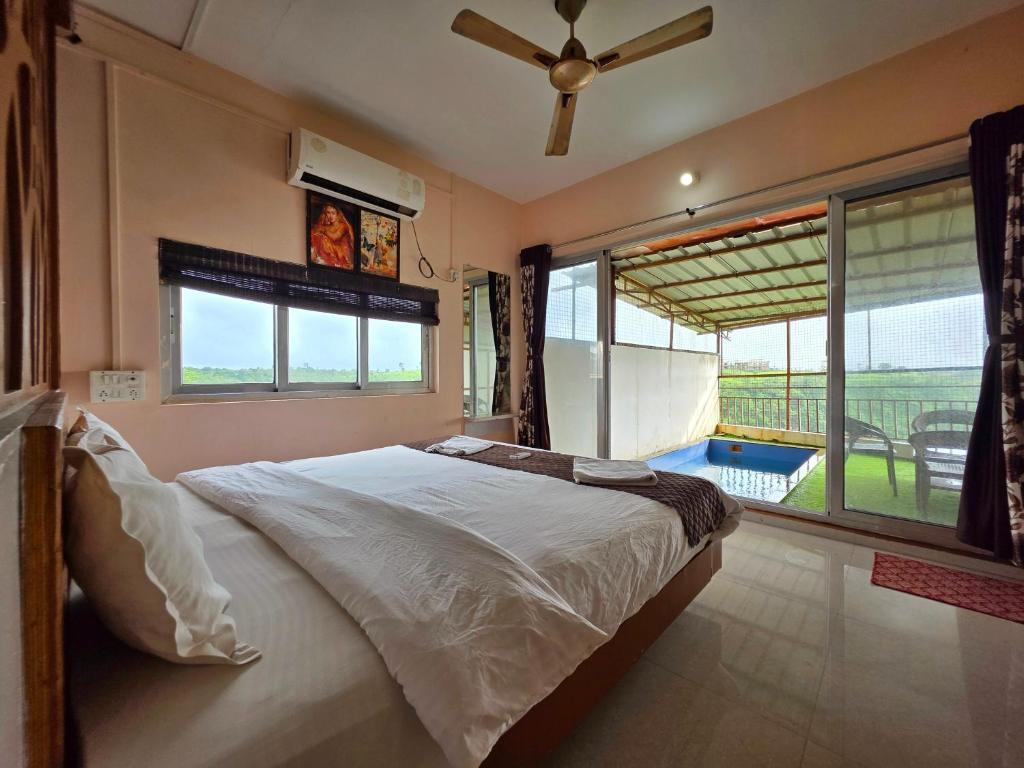 a bedroom with a large bed and a large window at Relax Adventure Resort in Igatpuri