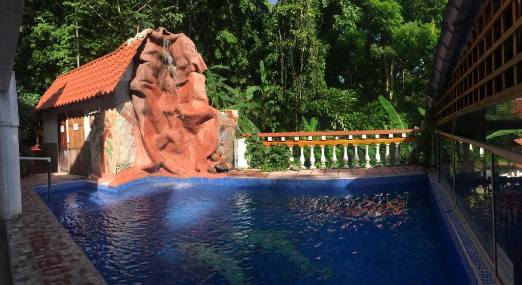 una piscina con un tobogán de agua en un patio en Hotel Coco Beach en Manuel Antonio