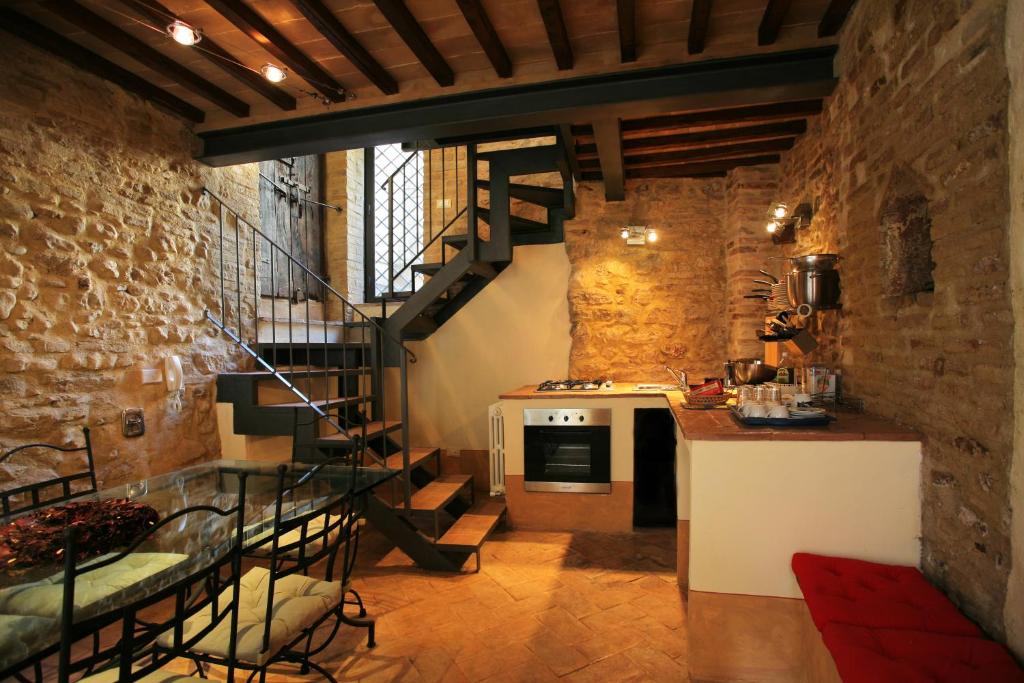 kuchnia ze spiralnymi schodami w ceglanej ścianie w obiekcie L’Arco Romanico w mieście Montefalco