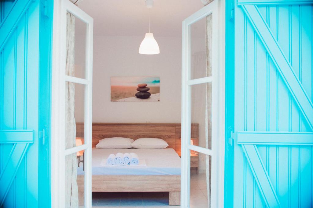 a bedroom with a bed with blue doors at Nerina Studios Agios Nikitas in Agios Nikitas