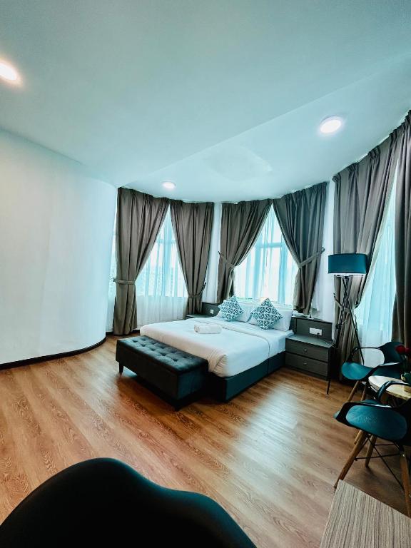 a bedroom with a bed and some windows at Lestari Inn Boutique Residence - Private Parking in Kuantan