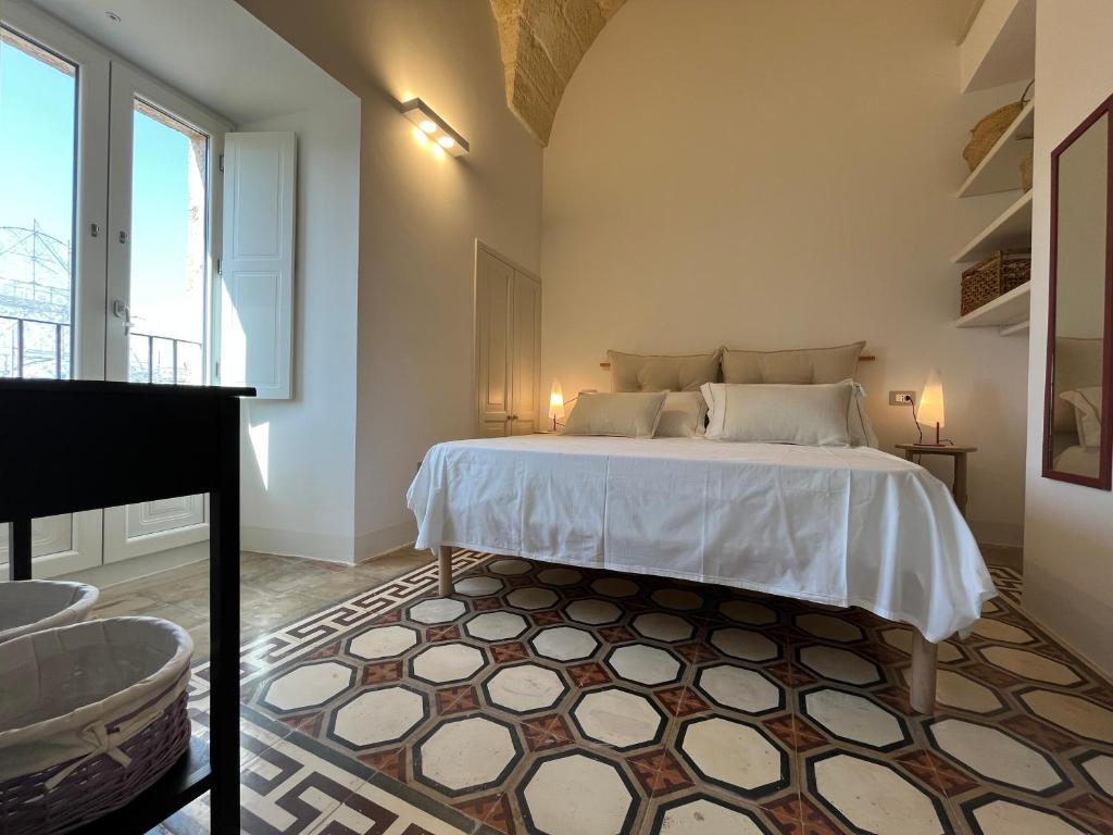 a bedroom with a bed and a large window at La Torretta dimora storica in Montesano Salentino