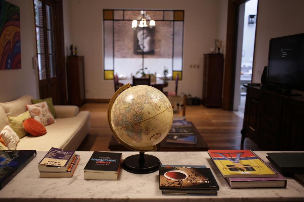 una sala de estar con una mesa con un globo terráqueo y libros en Cruce´s Hotel Boutique en Buenos Aires