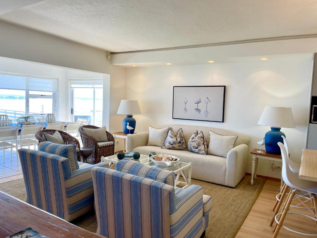 ein Wohnzimmer mit Sofa, Stühlen und einem Tisch in der Unterkunft Waterfront Seafront cottage C3 in Swakopmund