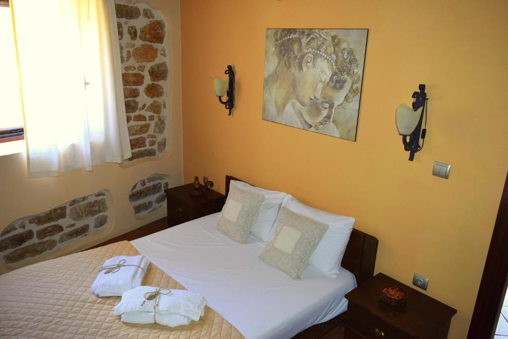 a bedroom with a bed with two towels on it at Tilemachos Traditional House in Vathi