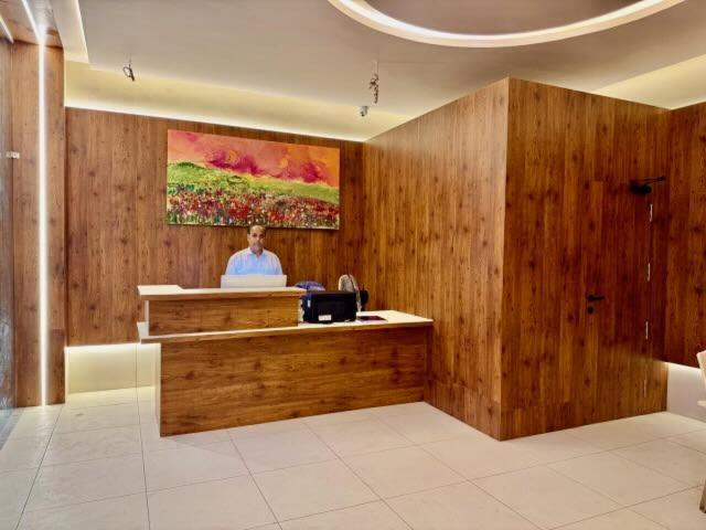 a man is standing at a counter in a lobby at Triviera Hotel Chirala in Chīrāla