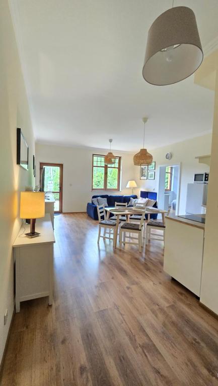 a kitchen and living room with a table and chairs at Apartamenty Józefina w willi Józefina in Szklarska Poręba