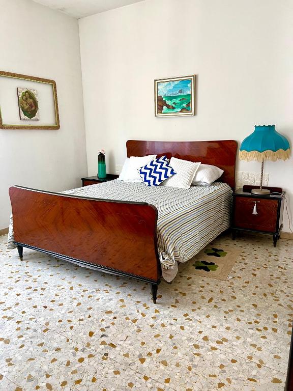 a bedroom with a large wooden bed in a room at Casa Nicola - Welchome in San Vito Chietino