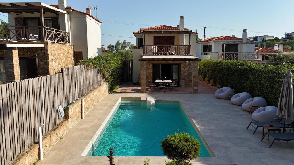 ein Swimmingpool vor einem Haus in der Unterkunft Velvet Pines Villa, Elani by Halkidiki Villas in Elani