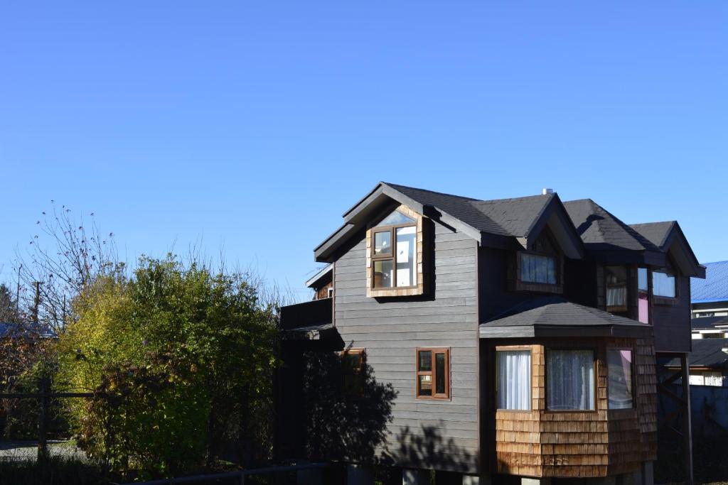 a house with a black and white house at Cabañas Estacion del Lago in Puerto Varas