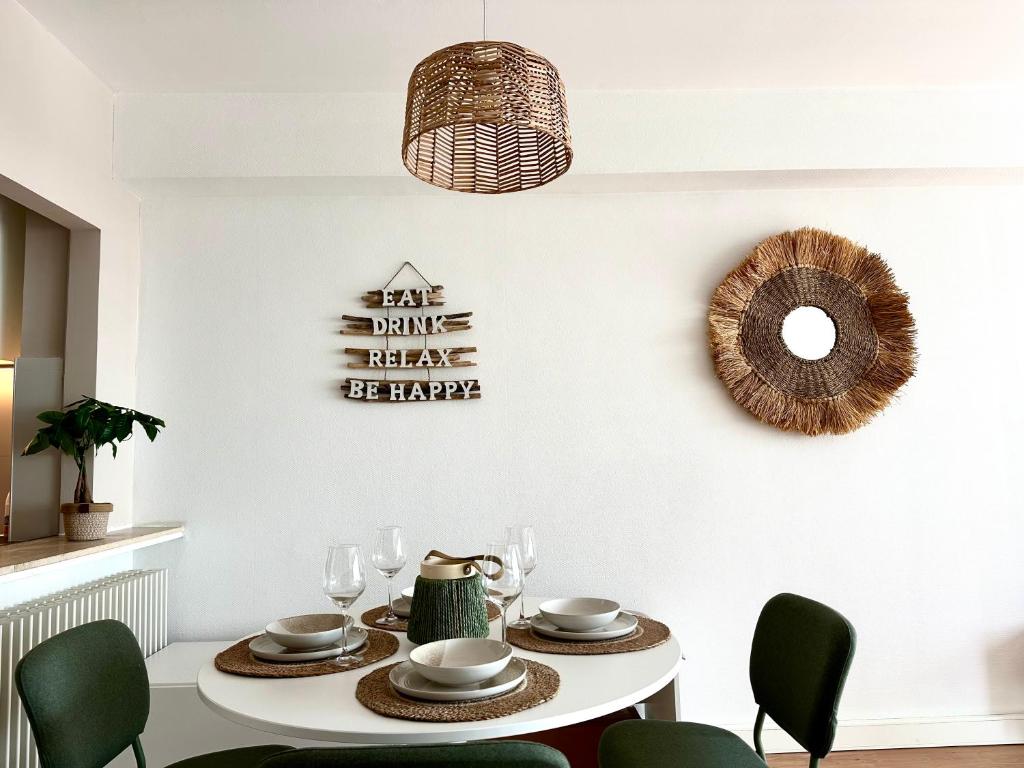 comedor con mesa blanca y sillas verdes en K Sunrise, en Ostende