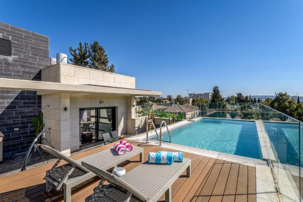 a swimming pool with a wooden deck and a swimming pool at Penthouse with pool jerusalem in Jerusalem