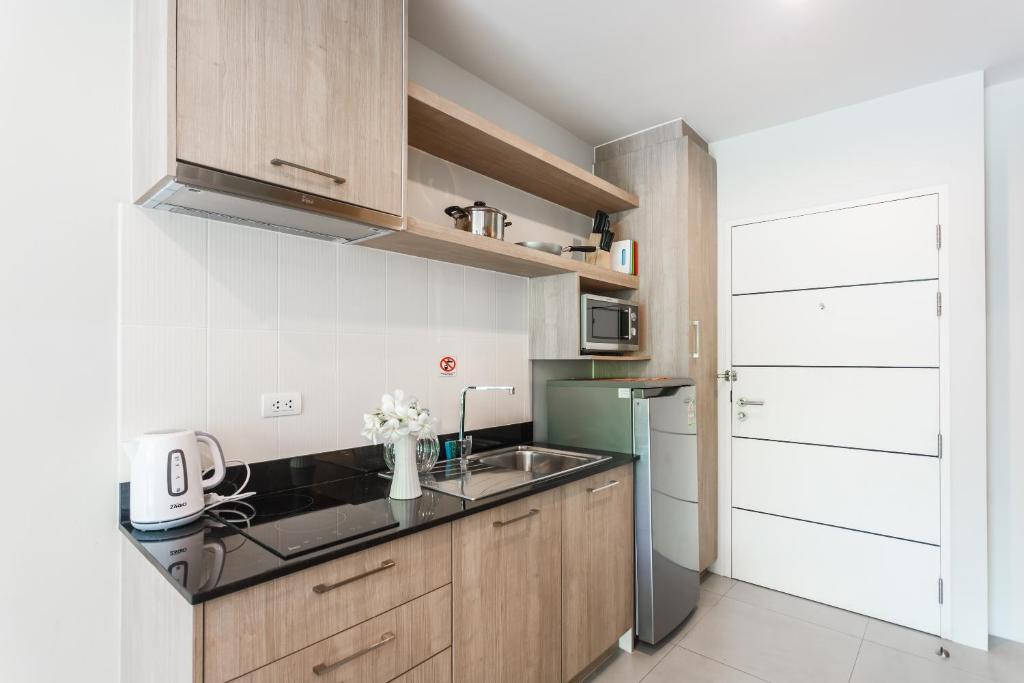 a kitchen with a sink and a refrigerator at Apartments at The Bliss Condo by Lofty in Patong Beach