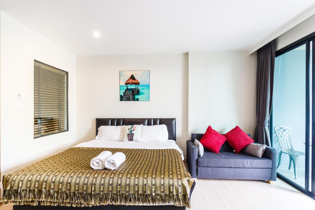 a bedroom with a bed and a couch at Apartments at The Bliss Condo by Lofty in Patong Beach