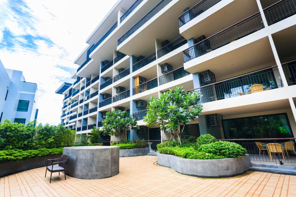 an apartment building with a courtyard with chairs and trees at Apartments at The Bliss Condo by Lofty in Patong Beach