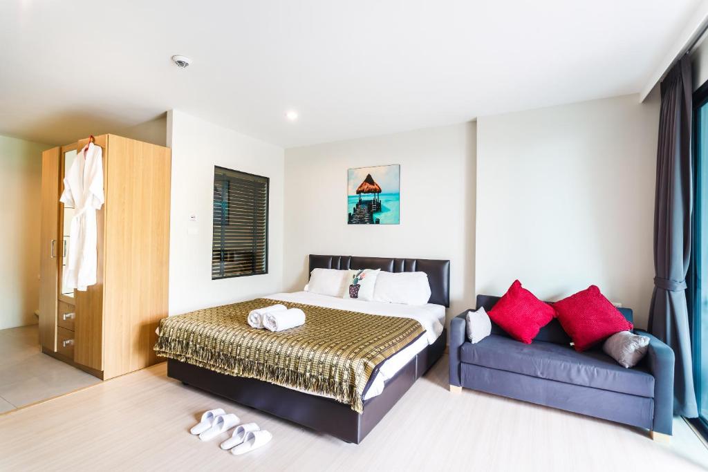 a bedroom with a bed and a couch at Apartments at The Bliss Condo by Lofty in Patong Beach