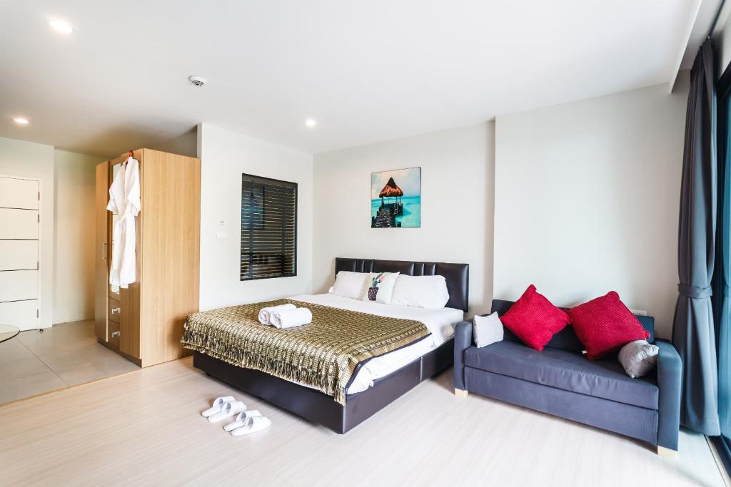a bedroom with a bed and a couch at Apartments at The Bliss Condo by Lofty in Patong Beach