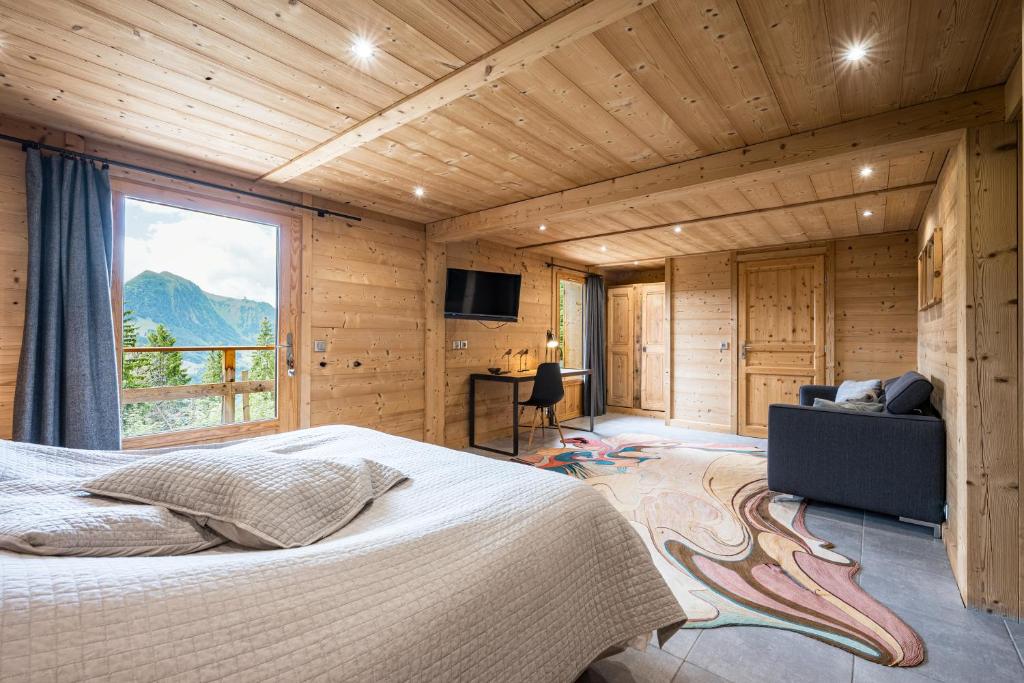 een slaapkamer met een bed en een groot raam bij Chalet Fnire in Manigod