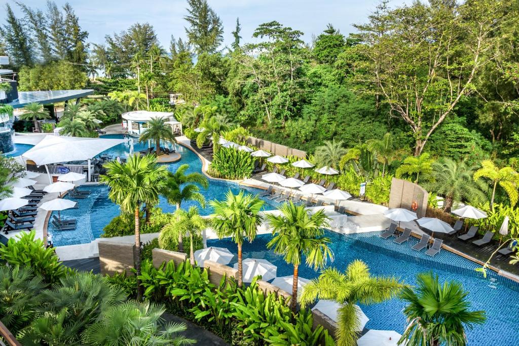 an aerial view of a resort pool with umbrellas and palm trees at Holiday Inn Resort Phuket Karon Beach, an IHG Hotel in Karon Beach
