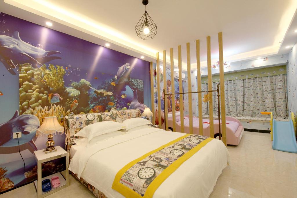 1 dormitorio con 2 camas y un mural del acuario en Xingyue Apartment Nimble Huamei Branch, en Guangzhou