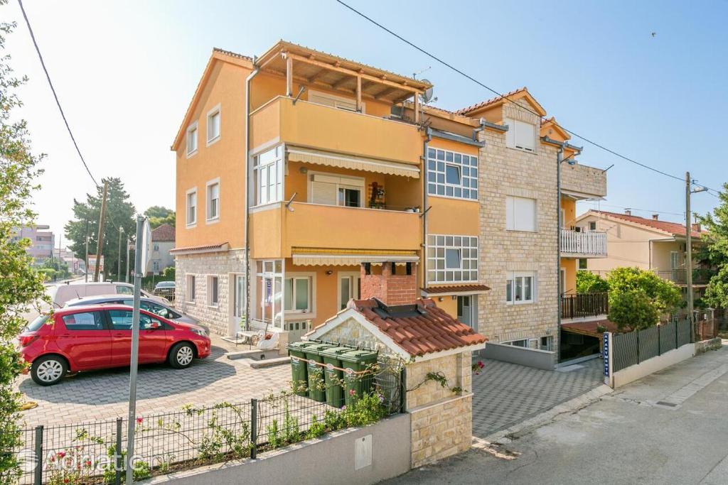 a red car parked in front of a building at Apartment Radalj in Kaštela