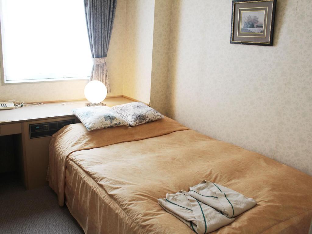 Postel nebo postele na pokoji v ubytování ロイヤルイン水戸-旧ホテルトレンド水戸-