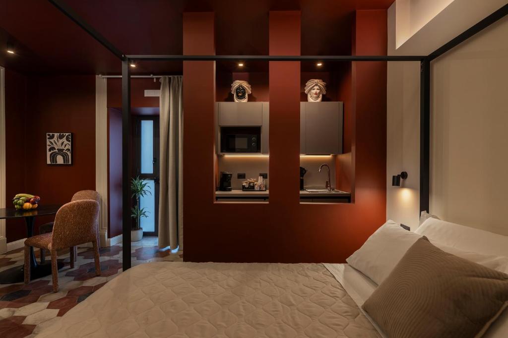 a bedroom with a bed and a table and a chair at Carmela Homes & Residences in Catania