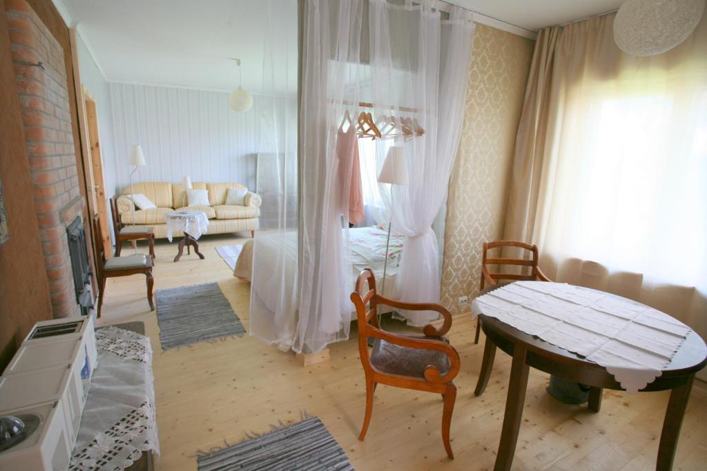 a living room with a bed and a table and a couch at Legendide Maja Valge Daami apartment Väikse viigi ääres in Haapsalu