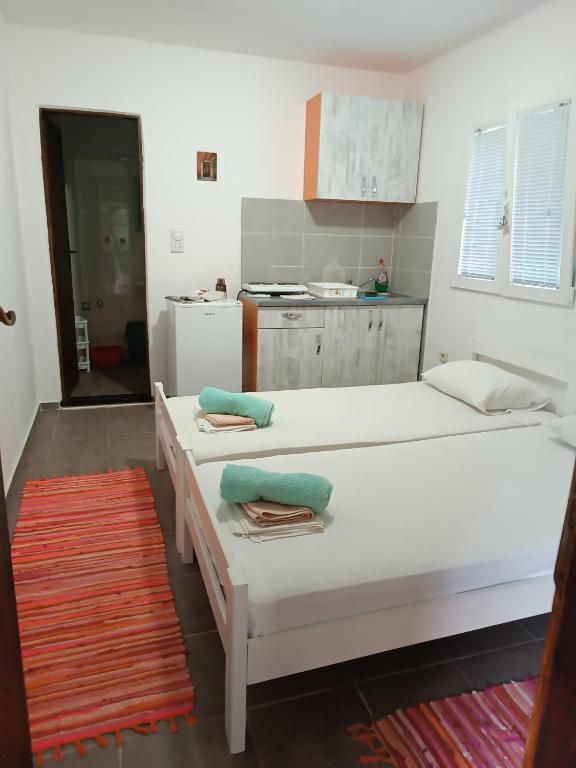 two beds in a room with a kitchen at M6 olive tree studio in Sutomore