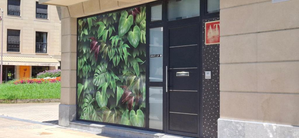 a glass door with a painting of leaves on it at ZARAUTZ LOFT 1 in Zarautz