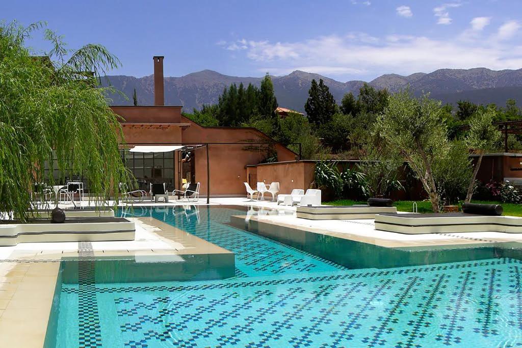 a swimming pool in a house with mountains in the background at Domaine Malika - Adults Only in Ouirgane