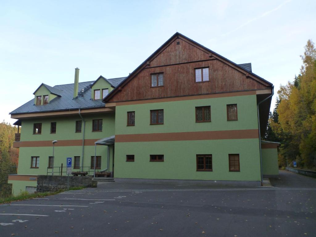 duży biały budynek z brązowym dachem w obiekcie Apartment Orbit Karlov P.P. w mieście Malá Morávka