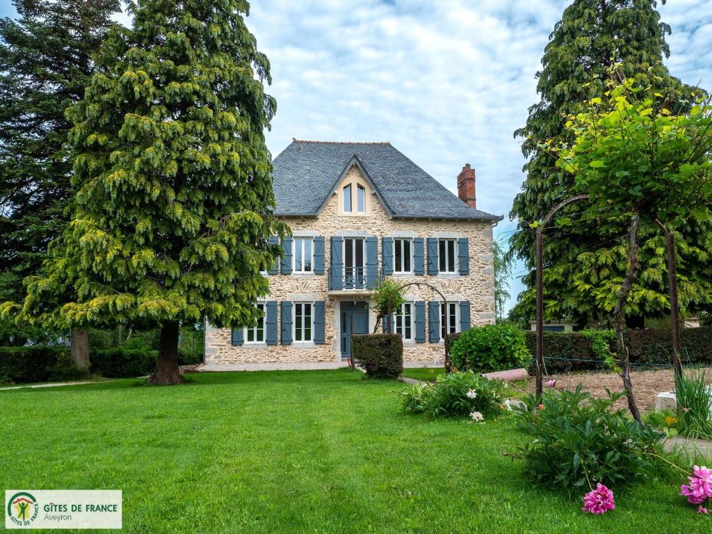 a house with two large trees in the yard at "La maison d'Octavie" in Rieupeyroux