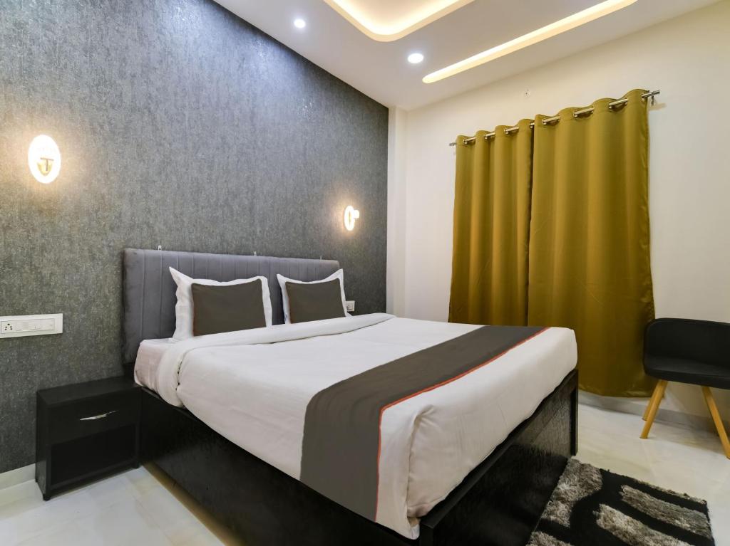 a bedroom with a large bed and a green curtain at Super Hotel O Iconic Stay in Indore
