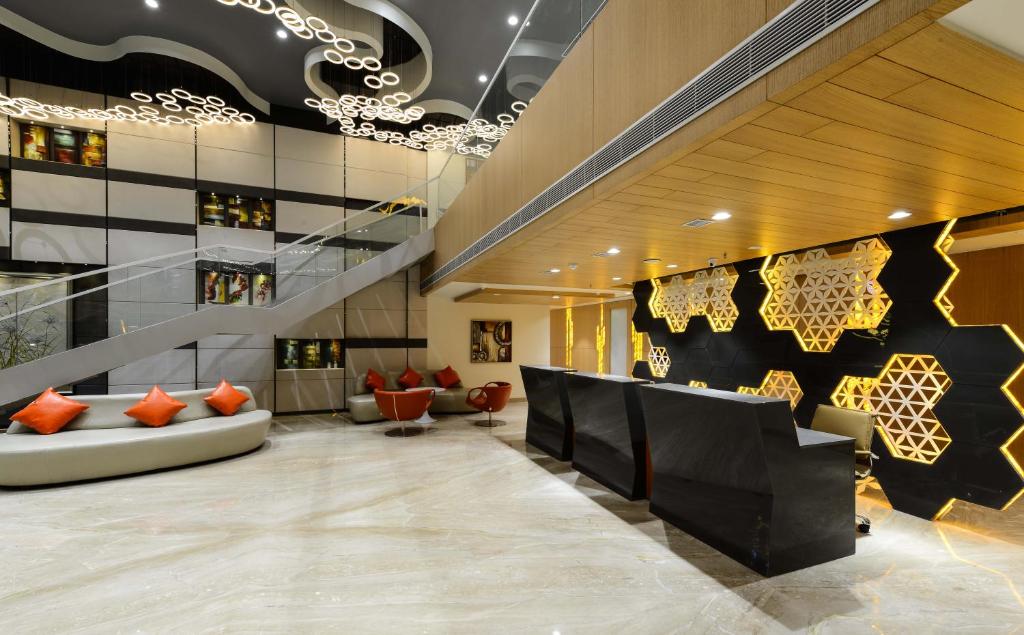 a lobby with couches and chairs in a building at Hotel Atishay in Bhopal