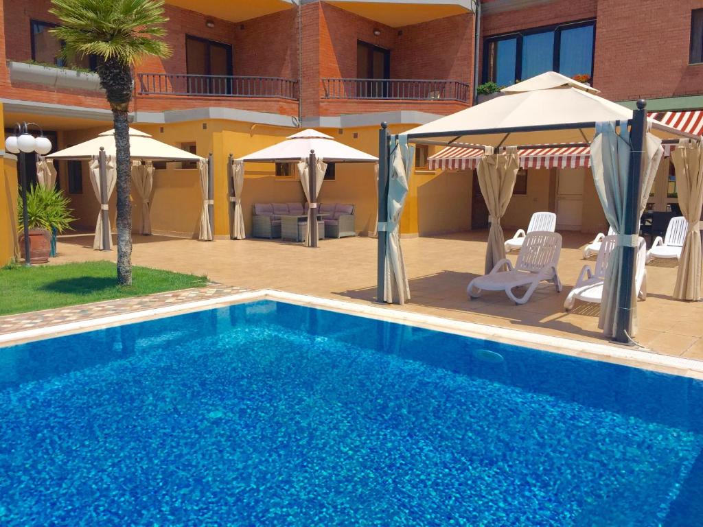 niebieski basen z parasolami i hotel w obiekcie Hotel Grillo w mieście Assemini