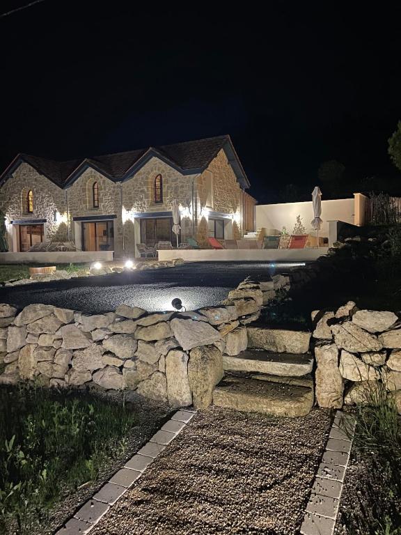 une grande maison avec un mur en pierre la nuit dans l'établissement Villa Julorian proche Saint Emilion au cœur des vignobles, à Sainte-Colombe