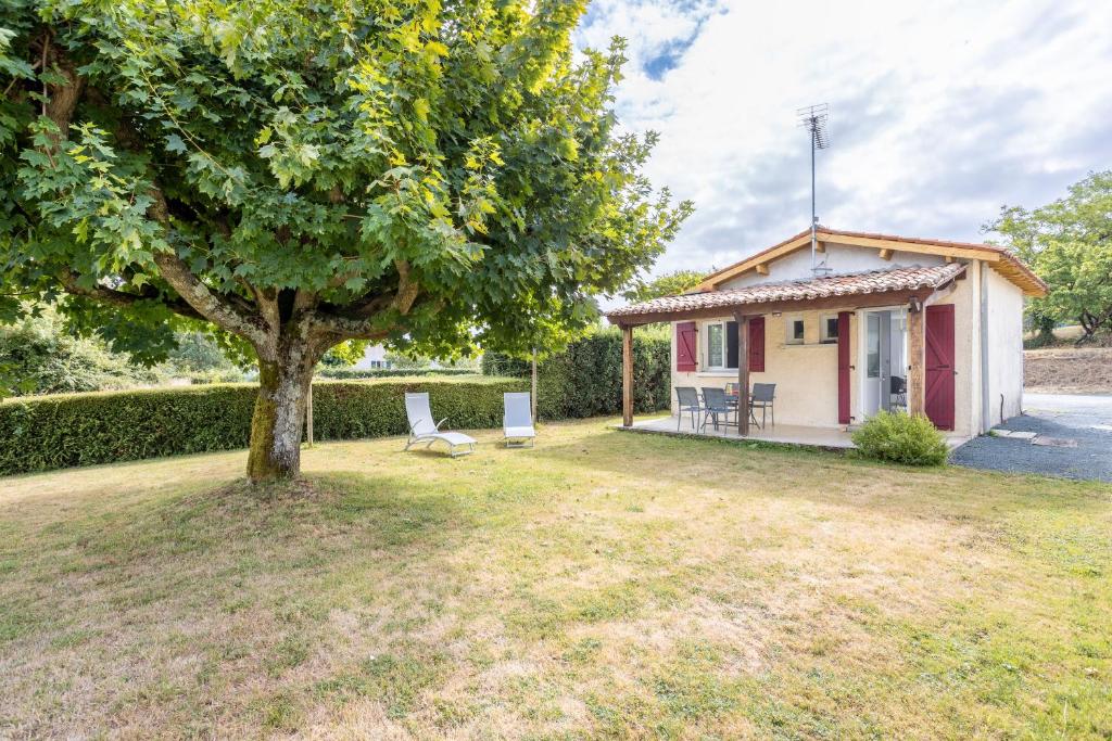 a small house with a tree in the yard at Maison de 2 personnes in Maillé