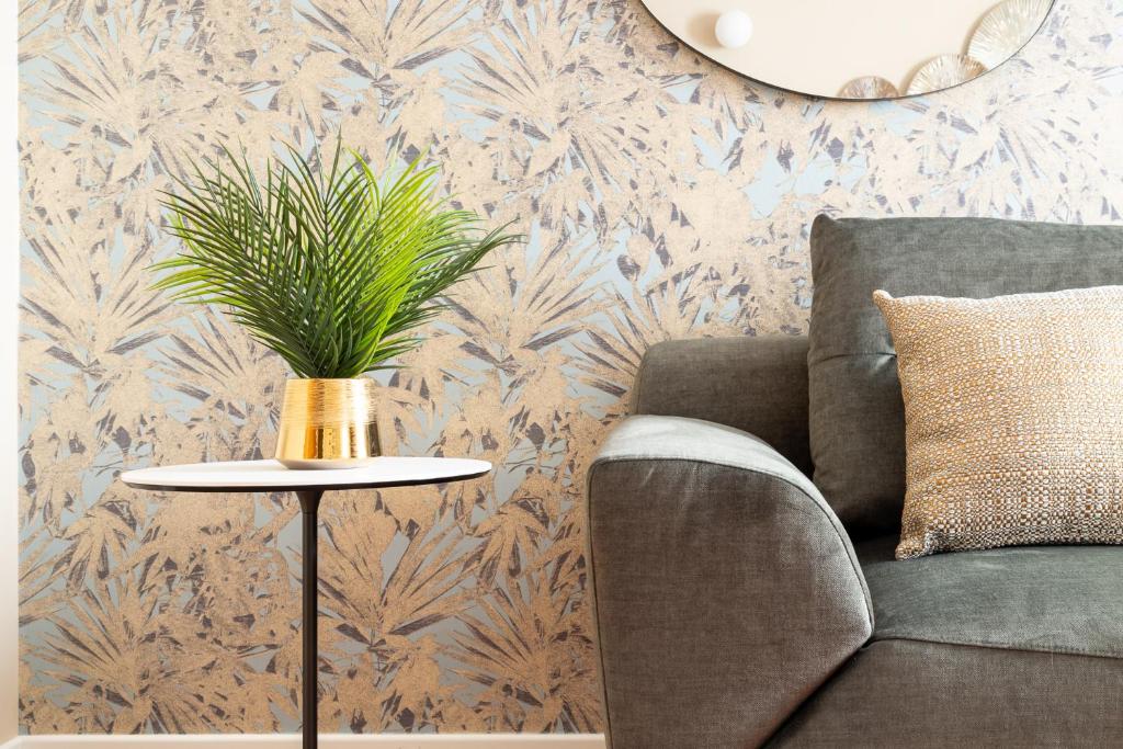 ein Wohnzimmer mit einer Couch und einem Tisch mit einer Pflanze in der Unterkunft NEW-Venice Suite San Marco 397 in Venedig