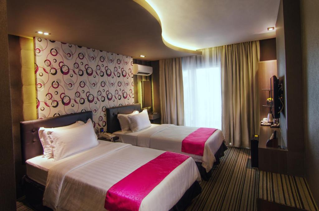 a hotel room with two beds and a window at Eloisa Royal Suites in Mactan